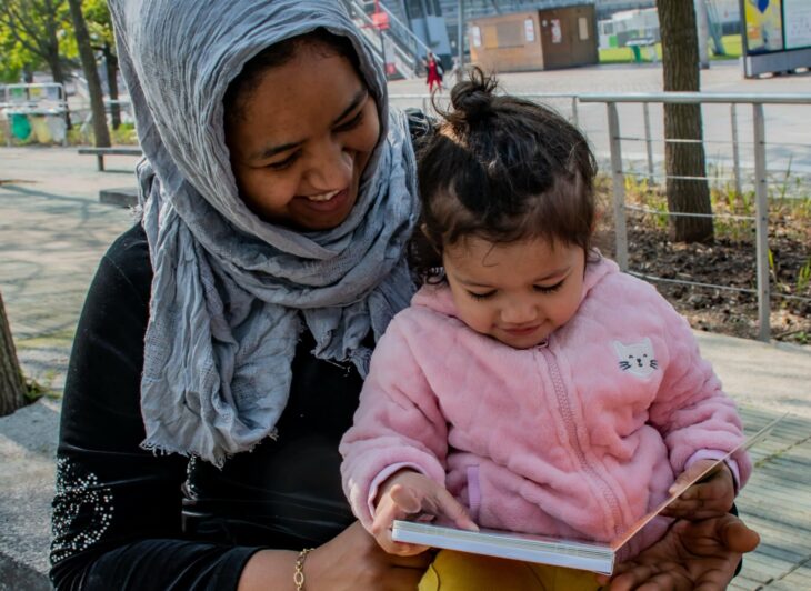 A caregiver and young child read together.
