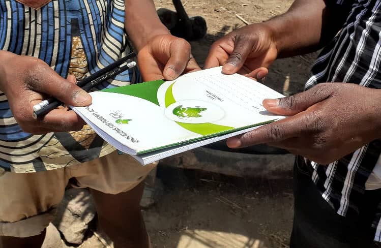 Adults pass a booklet between each other.