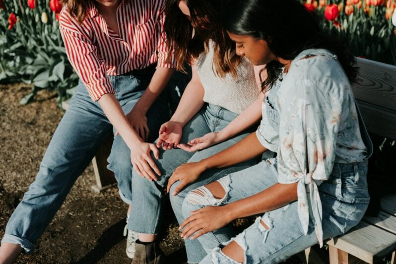 Three teenage girls comforting each other.