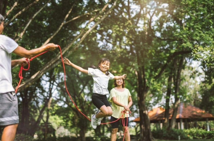 A family play joyfully with a skipping rope.