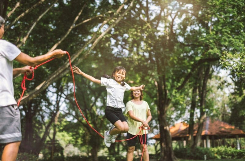 A family play joyfully with a skipping rope.