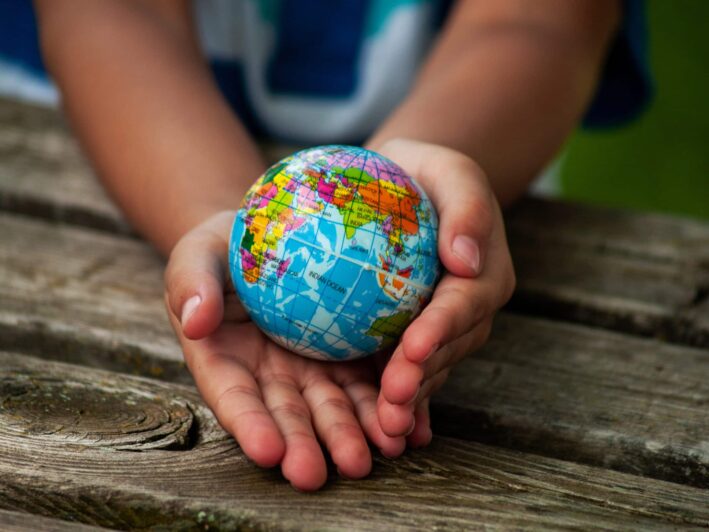 A child holds a small globe in their hands.