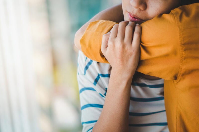 A young women is comforted by her friend.