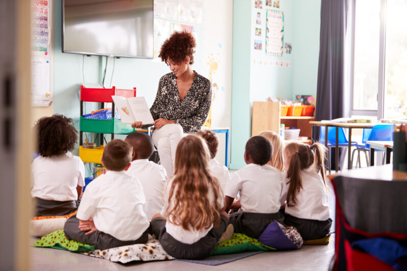 A teacher reads to a group of students at school.