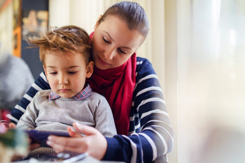 A young boy and his mother read a digital book together.