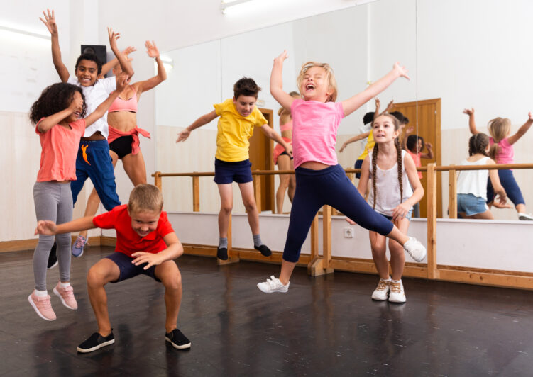 A group of children dance creatively.