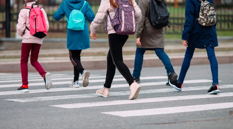 A group of children are crossing a crosswalk.