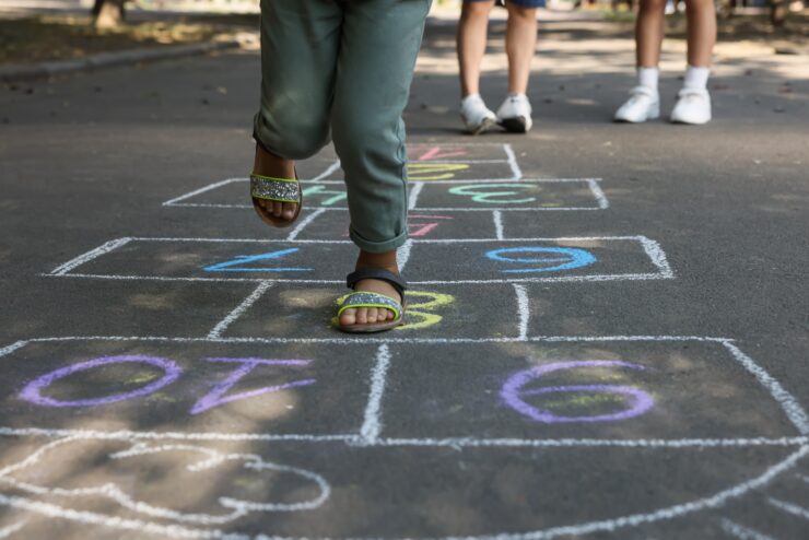 Children play hopscotch in the street.