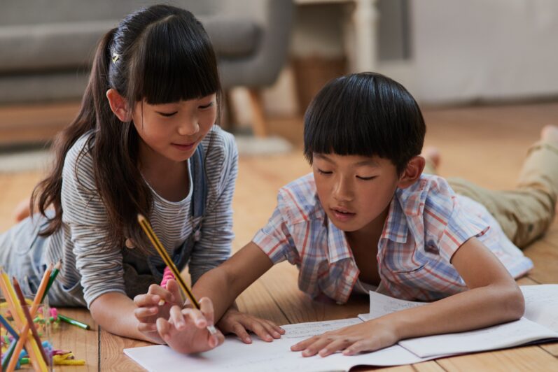 Two children are helping each other with homework.