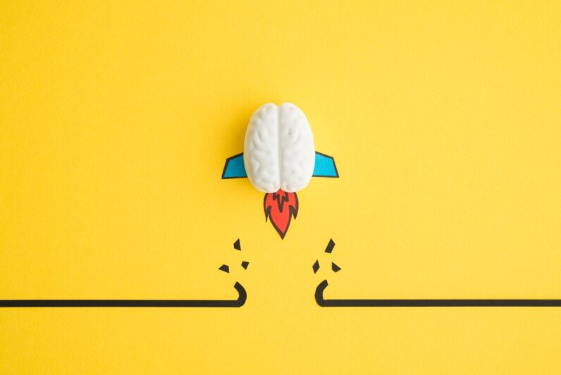 An abstract brain rocket breaks through an obstacle.