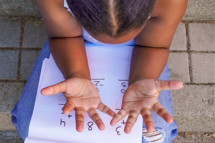 A child counts with her fingers.