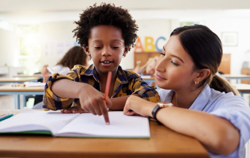 A teacher helps a student learn.
