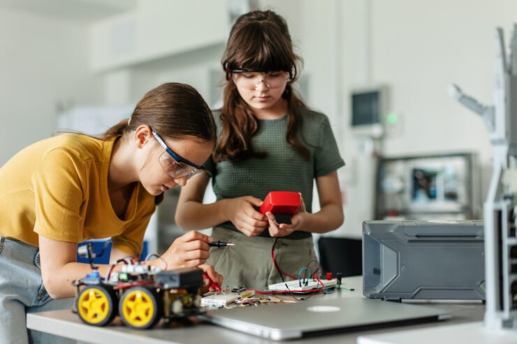 Two students build a robotic car.