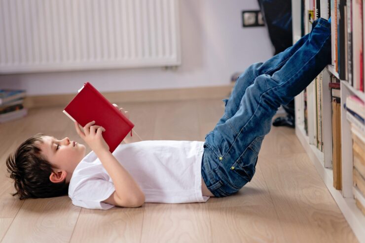 A child lies on the floor reading.