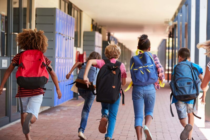 Children running down a school corridor.