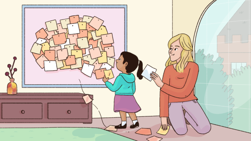An adult helps a child arrange colourful notes in the shape of a brain on a bulletin board.